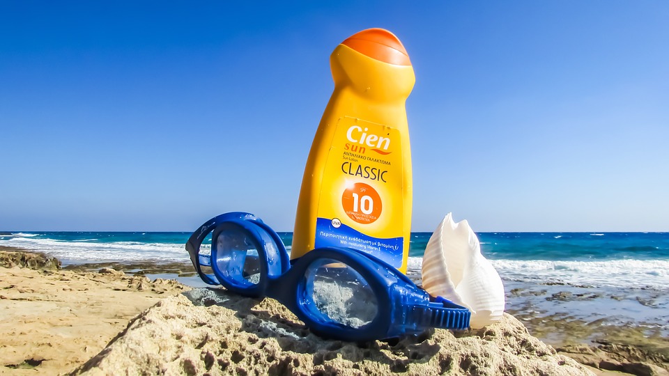 Sun lotion and goggles on a sunny beach